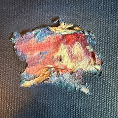 Close-up of the central patch: red, gold and blue paint with cracks and a small area where paint has flaked away, on a deep blue ground.
