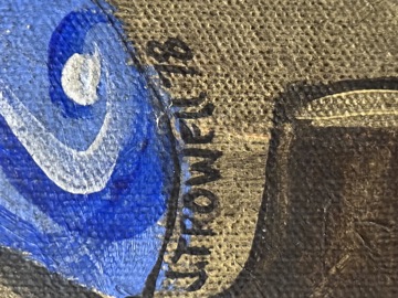 Close-up of the painted signature &lsquo;J. Trowell&rsquo; with a two-digit date, in black paint beneath the blue drapery near the base of the chair.