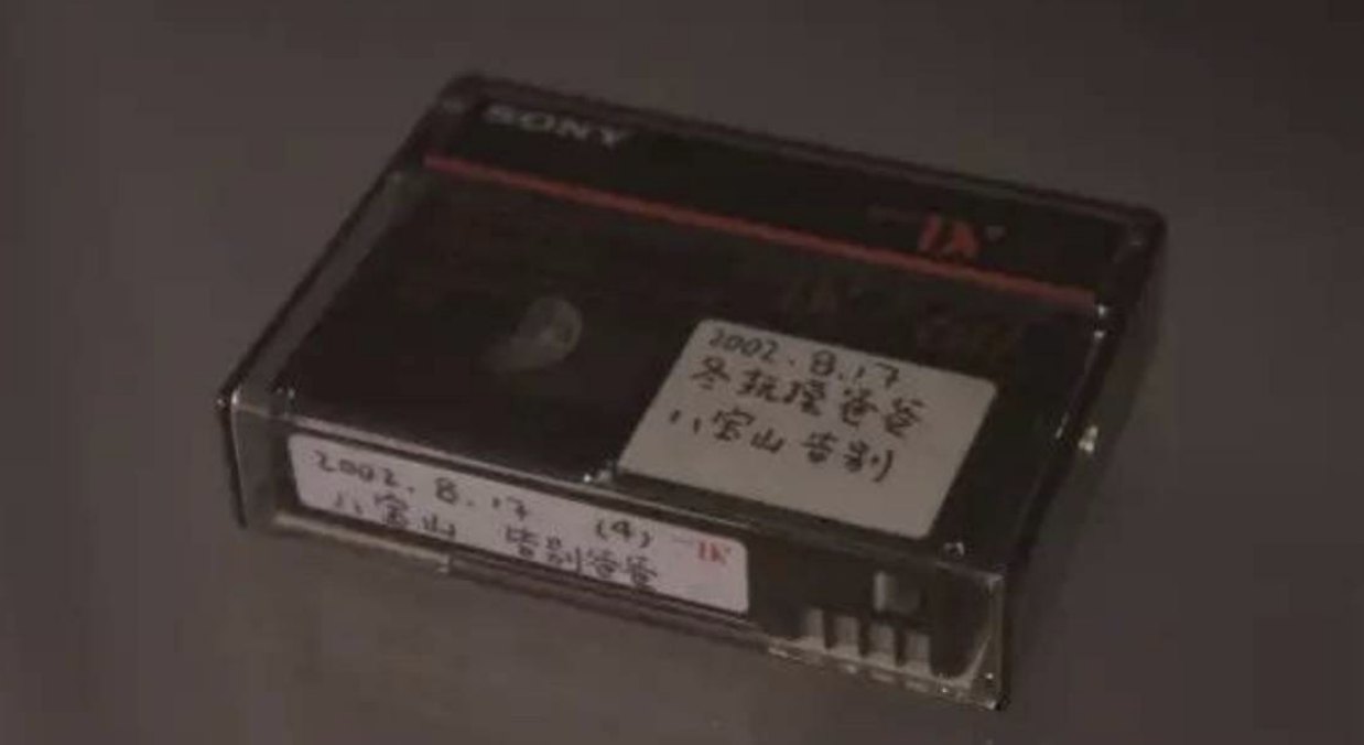 A Sony video cassette with handwritten Chinese labels dated 2002.8.17, resting on a dark surface.