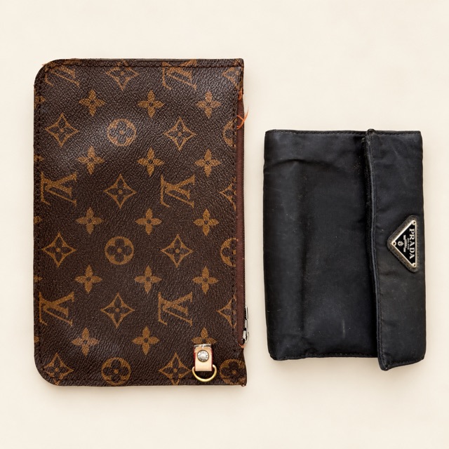 A Louis Vuitton monogram zip pouch beside a black nylon Prada wallet with the triangle logo.